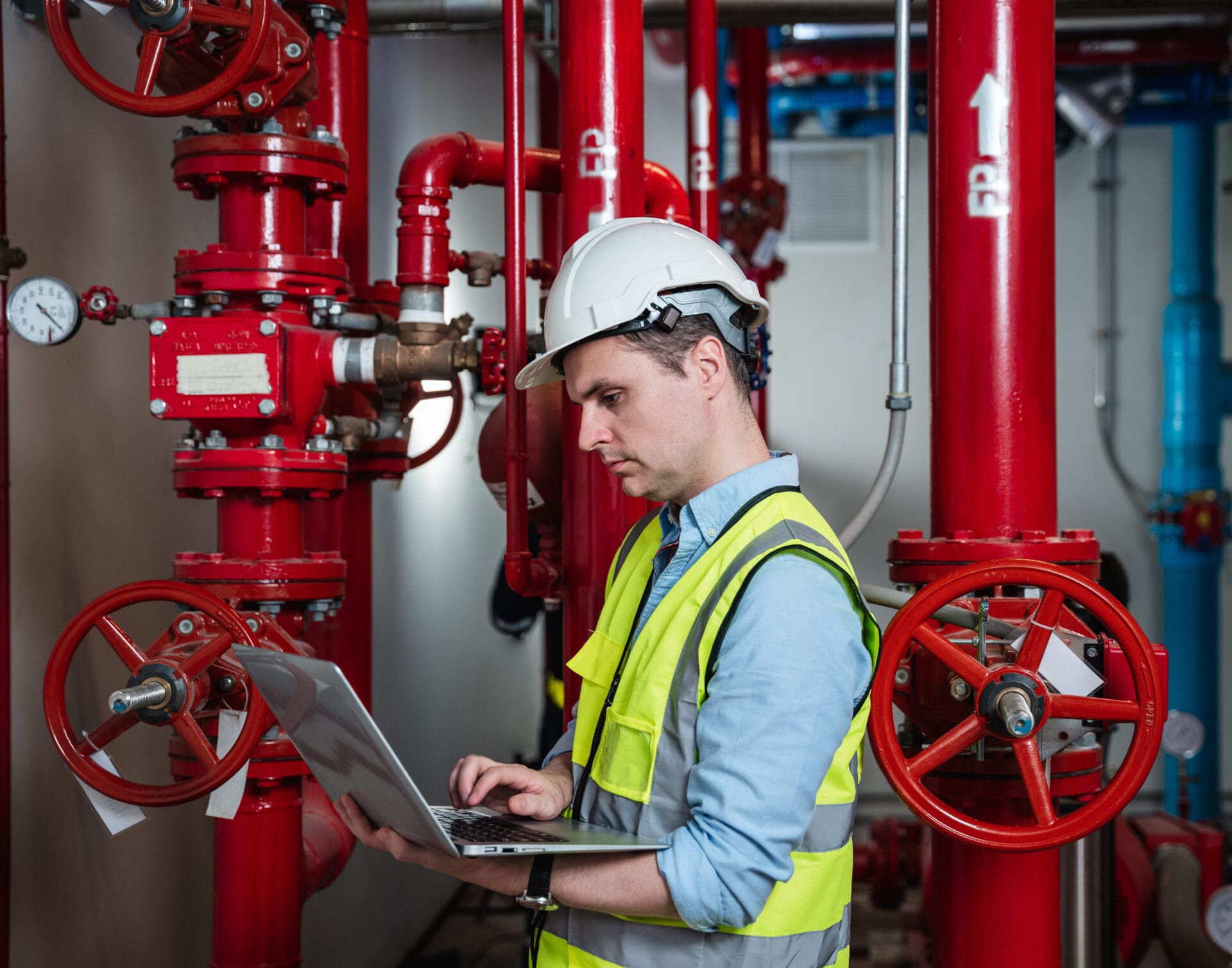 Engineers inspecting the inside plumbing and water valves of an industrial facility.