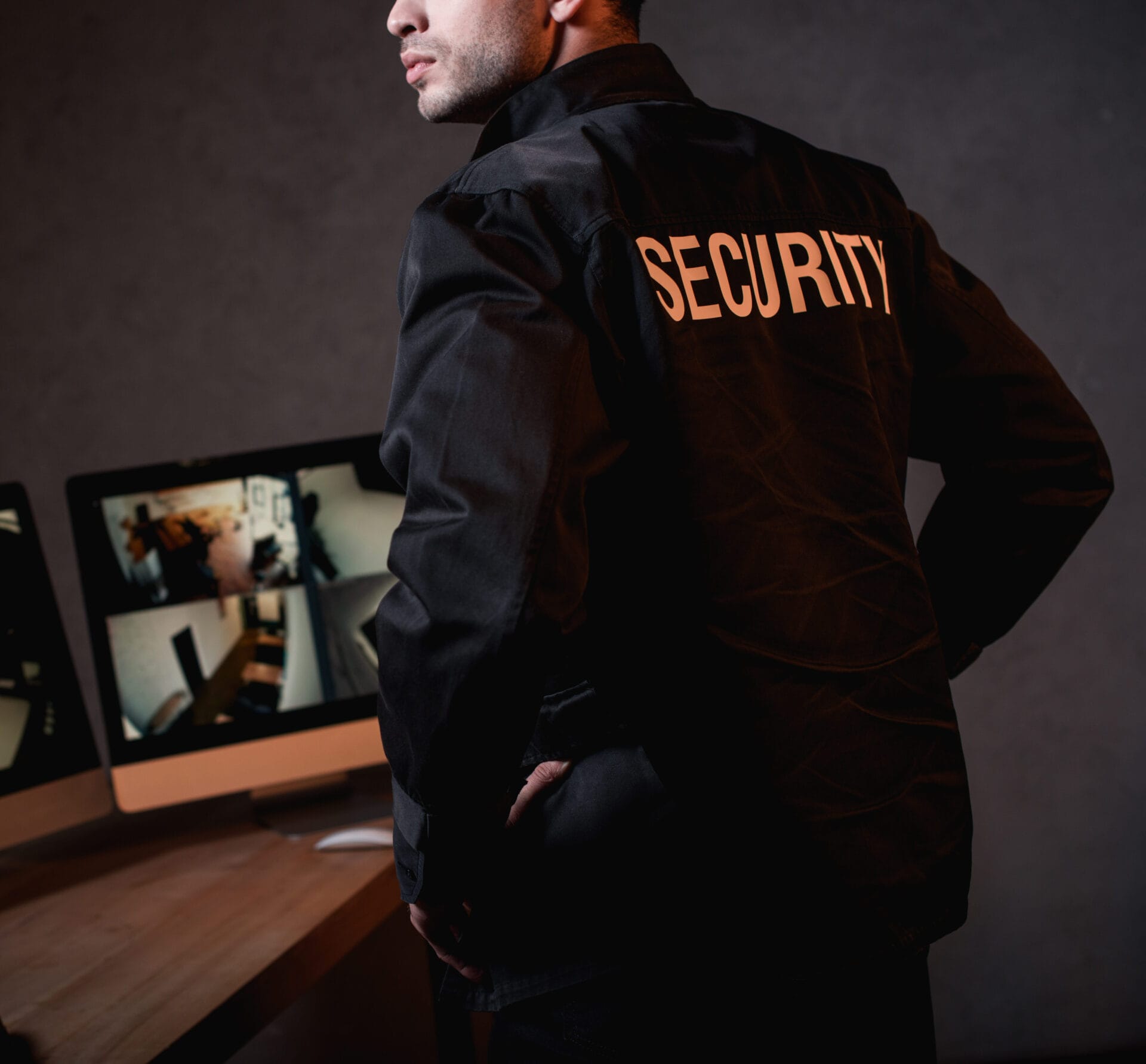 partial view of guard in black uniform at workplace