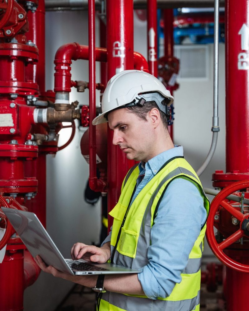Engineers inspecting the inside plumbing and water valves of an industrial facility.