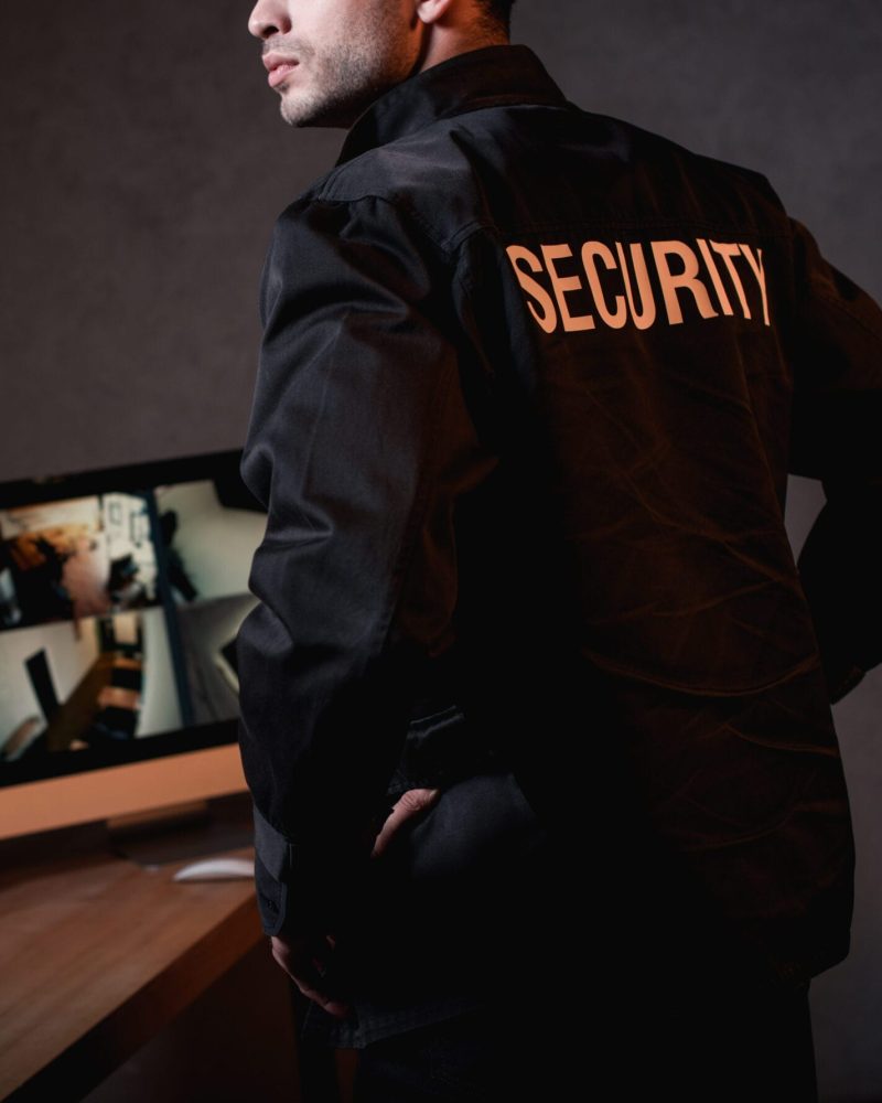 partial view of guard in black uniform at workplace